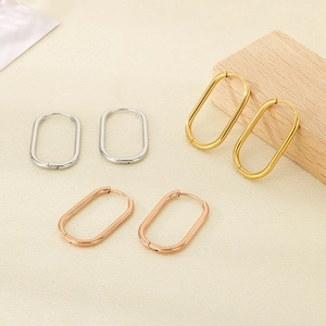 Close-up of geometric oval hoop earrings in silver, gold, and rose gold finishes