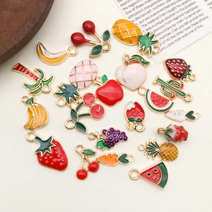 Detailed view of colorful enamel fruit charms including strawberry and pineapple for DIY jewelry