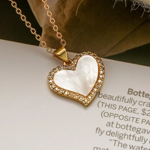 Macro detail of a 18K gold plated heart pendant with shell inlay and zircon accents
