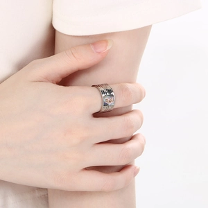 On-model shot of a wide hammered stainless steel ring with colorful abalone shell inlay