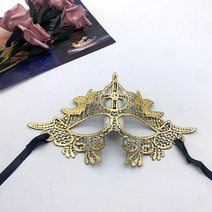Detailed close-up of golden lace embroidery masquerade mask with black satin ribbons