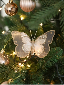 Détail d'un papillon décoratif pailleté avec plumes sur un sapin de Noël