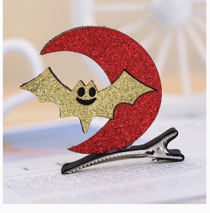 Detail of Halloween glitter bat and moon hair clips with black metal attachment