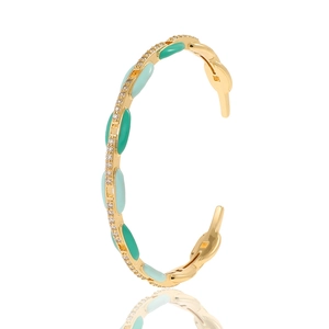 Detail of gold C-shaped cuff bracelet with light blue enamel and sparkling zircon accents