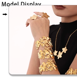 Detailed shot of golden flower wide open bracelets and floral jewelry set on a model