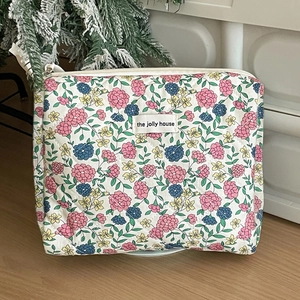 Close-up of vintage floral quilted makeup bag with zipper and the jolly house label