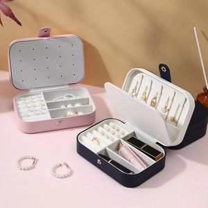Portable jewelry storage box in pink and blue with multi-functional interior compartments