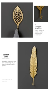 Detail of gold leaf and feather metal wall hooks showing texture and towel hanging function