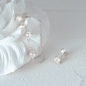 Detailed macro view of S925 silver stud earrings with zirconia stones and long chain