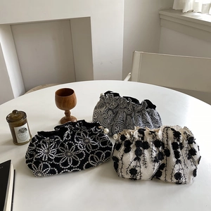 Detailed view of lace embroidered cosmetic bags with elegant pearl decorative buttons