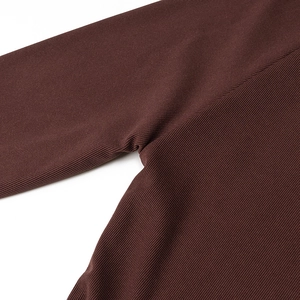 Vista macro delle cuciture rinforzate sul tessuto a maglia a coste marrone scuro