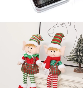 Detail of Christmas long-legged elf plush dolls with striped hats on a white mantelpiece