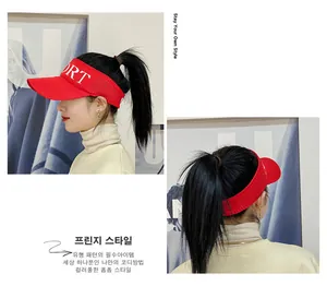 Detail view of red sun visor hat showing lateral SPORT logo and open top structure