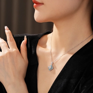 Close-up of a vintage floral pendant necklace with blue zircon and pearls on a model
