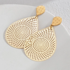 Detailed close-up of golden hollow water-drop earrings with vintage geometric patterns
