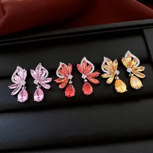 Drei Paar Zirkonia-Ohrhänger in Blumenform in Pink, Rot und Gelb auf schwarzer Schmuckbox
