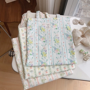 Dettaglio di tre borse tote in cotone con stampe floreali vintage blu rosa e giallo