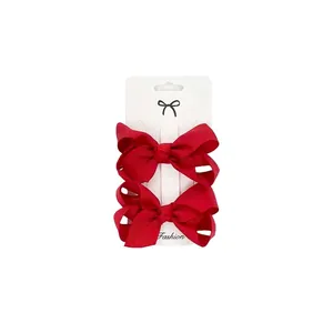 Detail of red grosgrain ribbon bow hair clips set on a professional white display card
