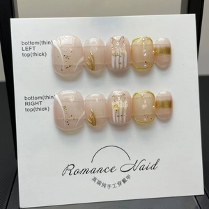 Detail of handmade press-on nails featuring 3D butterfly accents and gold leaf details