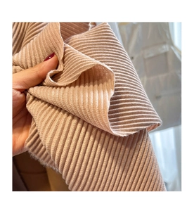Close-up of thick ribbed knit fabric in soft pink showing high-quality texture
