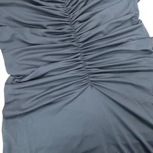 Detailed close-up of grey ruched fabric with vertical seam and textured pleats