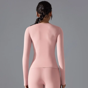 Rear view of sleek pink long-sleeve yoga set with high-stretch athletic fabric on model