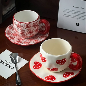 Macro shot of handmade ceramic coffee cup sets with hand-painted rose and heart patterns