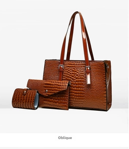 Brown crocodile embossed three-piece handbag set including tote, clutch, and wallet