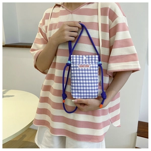 Detail of blue and white checkered mini crossbody bag with purple thick drawstring strap