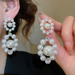 Gros plan de boucles d'oreilles perles à double cercle avec zircons brillants et dorure