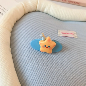 Détail de la pince à cheveux bleu ciel avec un joli motif d'étoile jaune et fini mat
