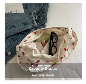 Detail of strawberry corduroy tote bag showing spacious interior with daily essentials
