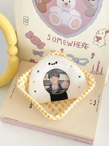 Detail of plush onigiri badge holder with anime character pin on checkered tray