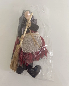 Detail of a handmade witch doll with broom in plastic packaging for Halloween decor