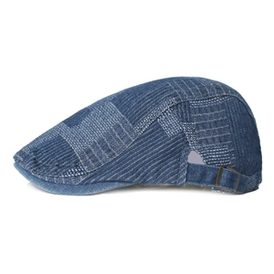 Béret en denim bleu avec boucle métallique réglable sur un fond blanc pur