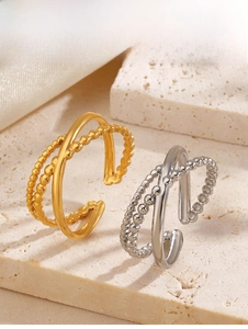 Minimalist double-layer stainless steel ring with beaded texture on a travertine background