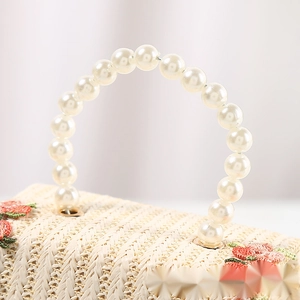 Handmade beige woven straw handbag with pearl handle and embroidered flower detail