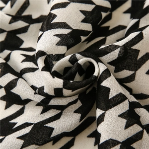 Detailed view of the classic black and white houndstooth fabric texture on a soft shawl scarf