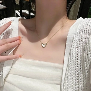 Elegant gold heart pendant necklace with white mother-of-pearl inlay on model