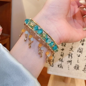 Détail du bracelet multicouche avec perles bleues craquelées et pampilles métalliques