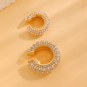 Detail of C-shaped gold ear cuff set with faux pearls and sparkling rhinestones