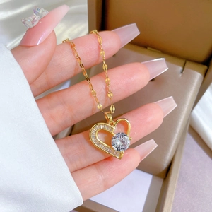Detail of gold heart pendant with rectangular diamonds and a large round cubic zirconia