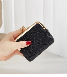 Close-up of black woven texture coin purse with golden kiss-lock closure detail