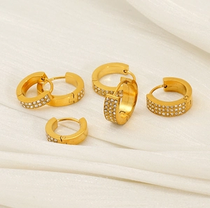 Detailed macro of gold huggie hoop earrings with triple-row white zircon pavé setting