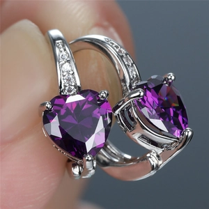 Macro shot of heart-shaped purple zircon earrings with small micro-pave diamonds detail