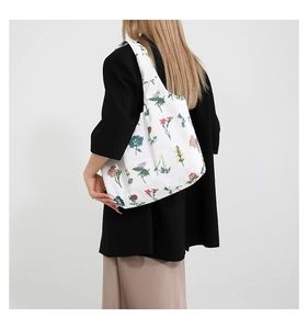 Detailed back view of a white floral tote bag worn over a black blazer for a stylish look