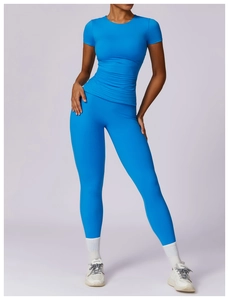 Front view of a model wearing a bright blue yoga set with short sleeve top and leggings