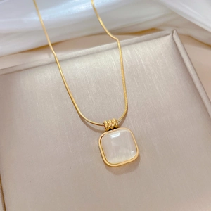 Detail of square cat eye stone pendant on a gold snake chain necklace