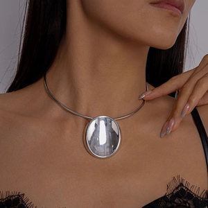 Detailaufnahme eines polierten silbernen Chokers mit minimalistischem ovalem Metallanhänger