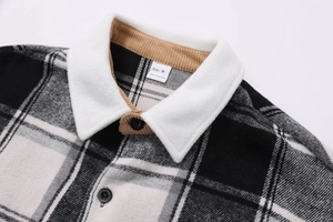 Detailed close-up of plaid shirt collar with khaki corduroy lining and button detail